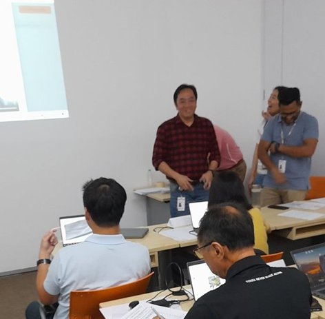 A participant presenting how their team used AI to solve a work problem